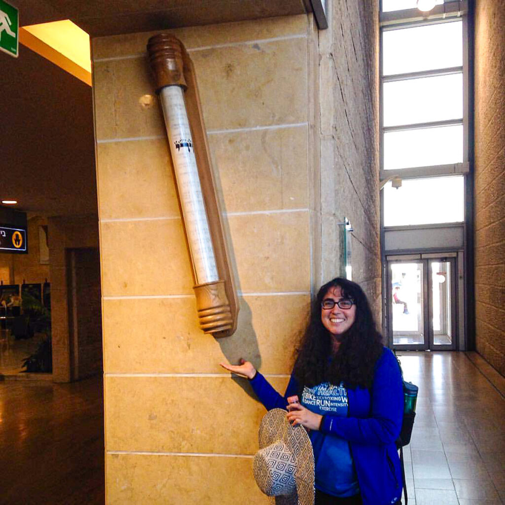 Me with the giant Mezuzah at Ben Gurion Airport. The Mezuzah, in Jewish tradition holds a tiny scroll with the Shema that is placed on the doorpost, a biblical command from the Torah.