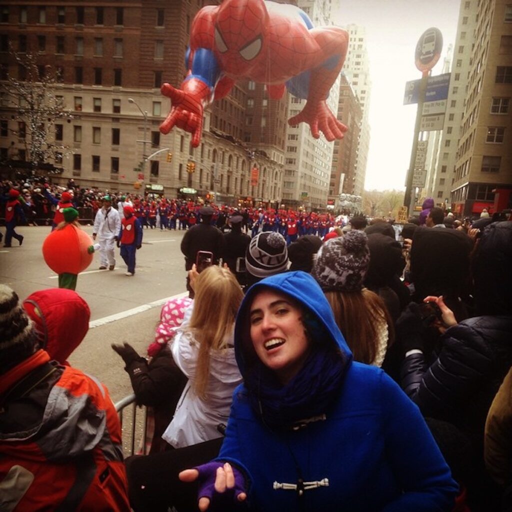 Sarah at the Macy's Thanksgiving Day Parade in NYC with the Spiderman balloon in the background