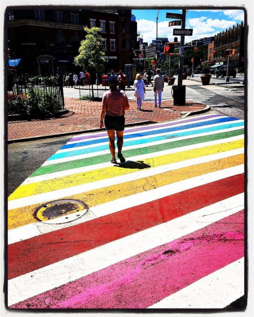 Sarah walking the Rainbow crosswalk outside Stonewall Inn in NYC