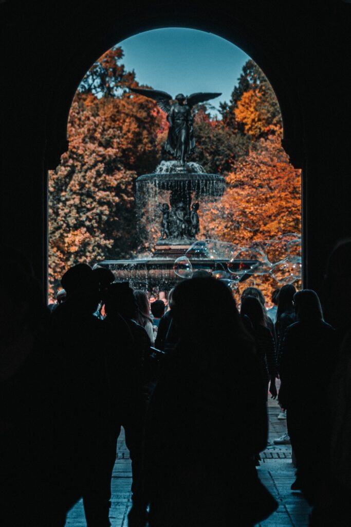 Bethesda Fountain during the fall in New York in Central Park, with orange leaves and silhouettes of onlookers
