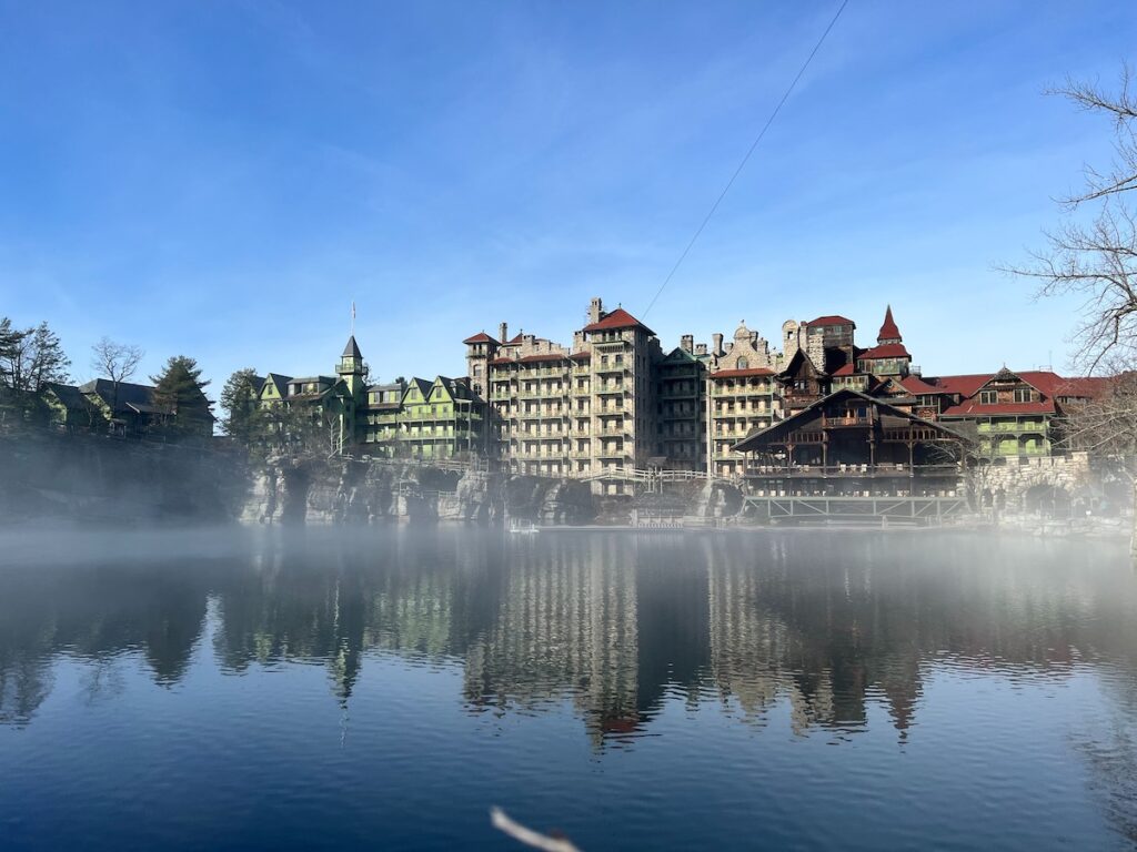 Mohonk Mountain House Resort from the lake with reflection, fog and blue sky in NY